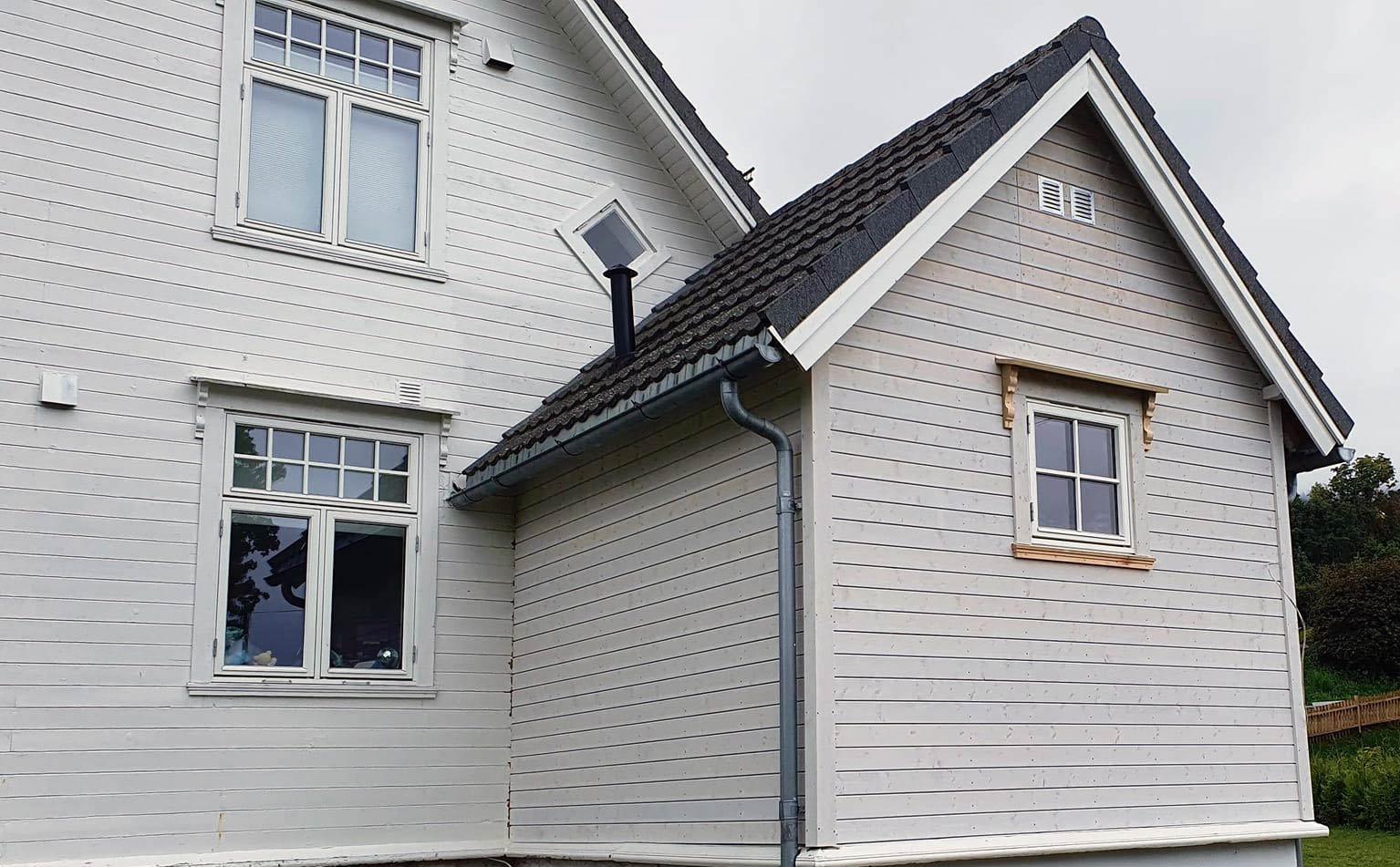 A light grey house with new cladding and white trim