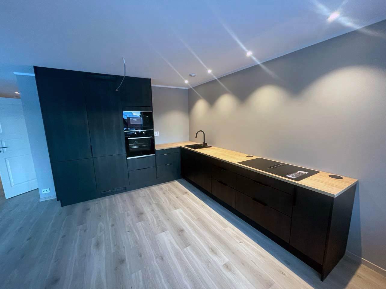 A new black kitchen with tall cabinets and a long worktop