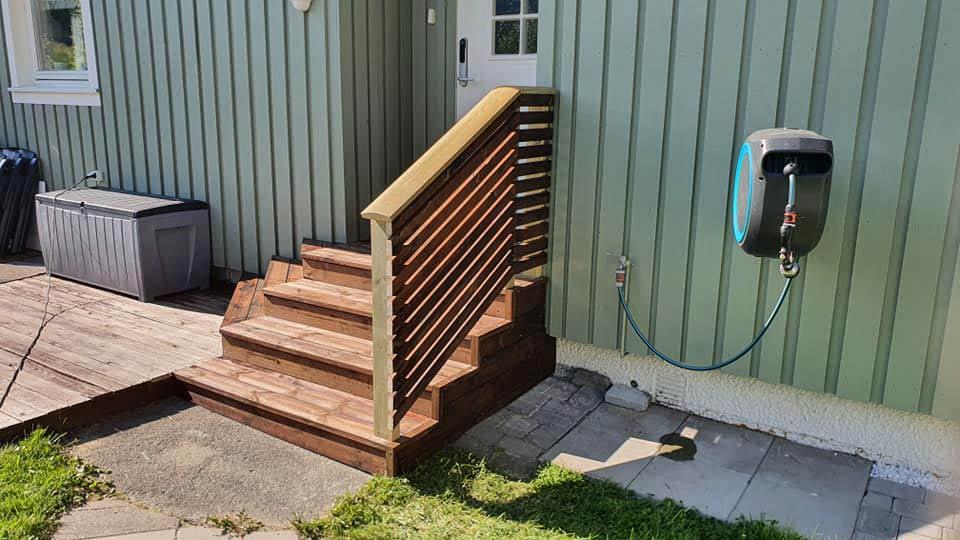 New wooden steps with a slatted side rail up to a green house